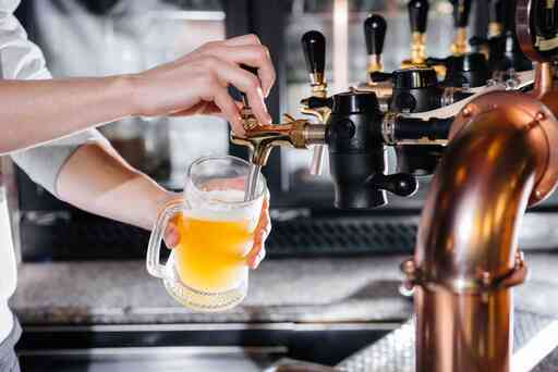 close-up-bartender-filling-mug-light-beer-bar-counter-pub