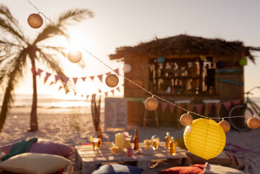 lanterns-hanging-blankets-cushions-are-places-around-table-with-surfing-lessons-hut-standing-background-sunny-day
