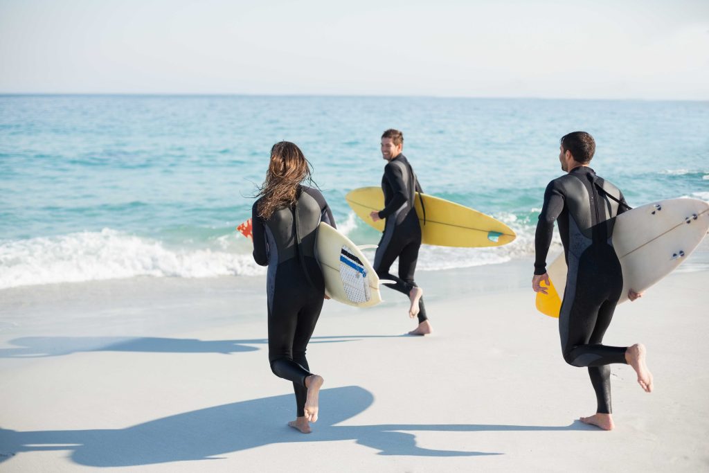 group-friends-wetsuits-with-surfboard-sunny-day