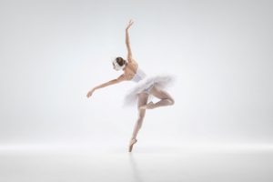 Graceful classic ballerina dancing isolated on white studio background