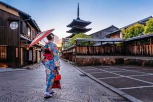 Woman wearing japanese traditional kimono with umbrella at yasaka pagoda and sannen zaka street in kyoto, japan